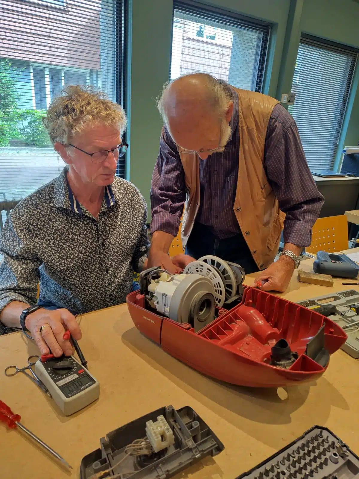 vrijwilligers van repaircafe repareren stofzuiger